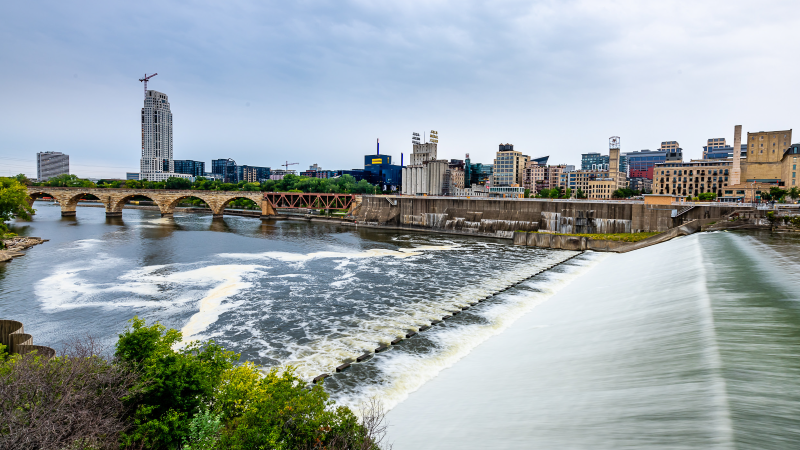 photo of St. Anthony Falls with the Stone Arch Bridge and downtown skyline in the background