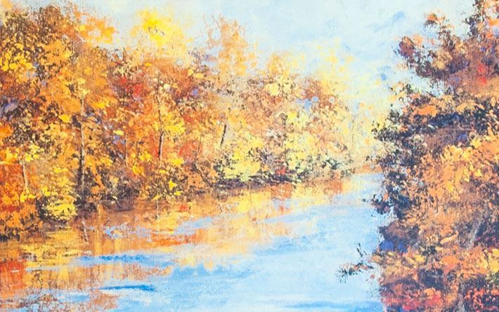 Detail view of a river with trees on both banks in the fall