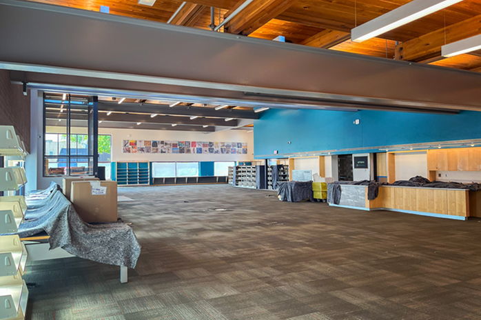 large room with tiled carpet, the furniture pushed to the sides